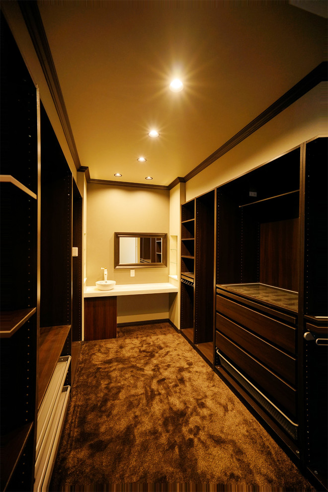 Пример оригинального дизайна: большая гардеробная комната унисекс в стиле модернизм с коричневыми фасадами, коричневым полом и потолком с обоями