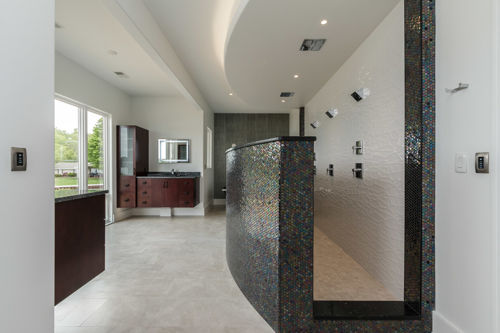 This is an example of a large contemporary master bathroom in Other with flat-panel cabinets, medium wood cabinets, a freestanding tub, an open shower, a bidet, multi-coloured tile, glass tile, white walls, porcelain floors, a vessel sink, quartzite benchtops, an open shower and black benchtops.