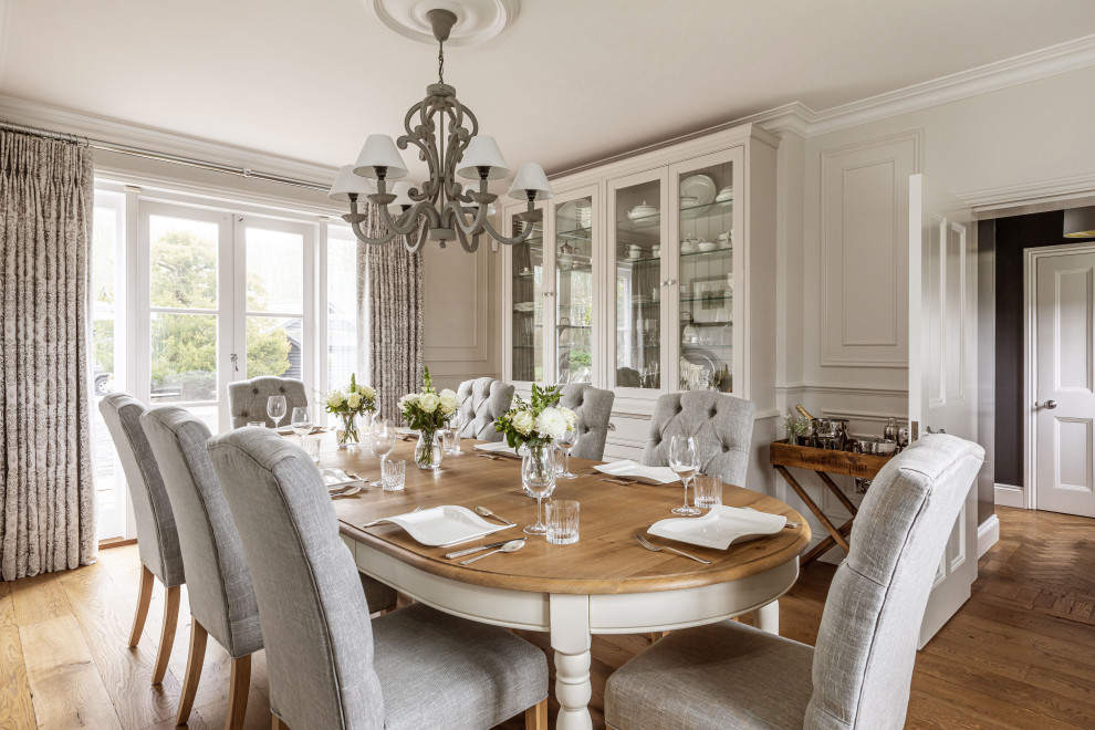 Design ideas for a large traditional separate dining room in Essex with beige walls, medium hardwood floors, brown floor and panelled walls.
