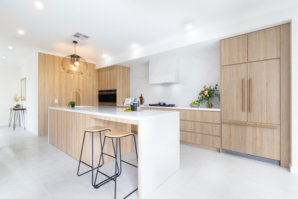 This is an example of a medium sized modern galley kitchen/diner in Sydney with a built-in sink, all styles of cabinet, all types of cabinet finish, marble worktops, white splashback, marble splashback, black appliances, marble flooring, an island, white floors, white worktops and all types of ceiling.