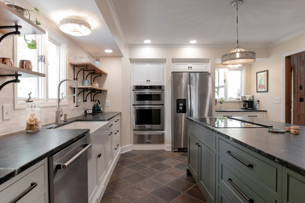 Exempel på ett avskilt, mellanstort lantligt svart svart l-kök, med en rustik diskho, luckor med profilerade fronter, gröna skåp, bänkskiva i täljsten, vitt stänkskydd, stänkskydd i keramik, rostfria vitvaror, skiffergolv, en köksö och flerfärgat golv