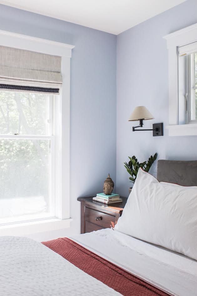 This is an example of a mid-sized transitional master bedroom in Portland Maine with blue walls, medium hardwood floors and brown floor.