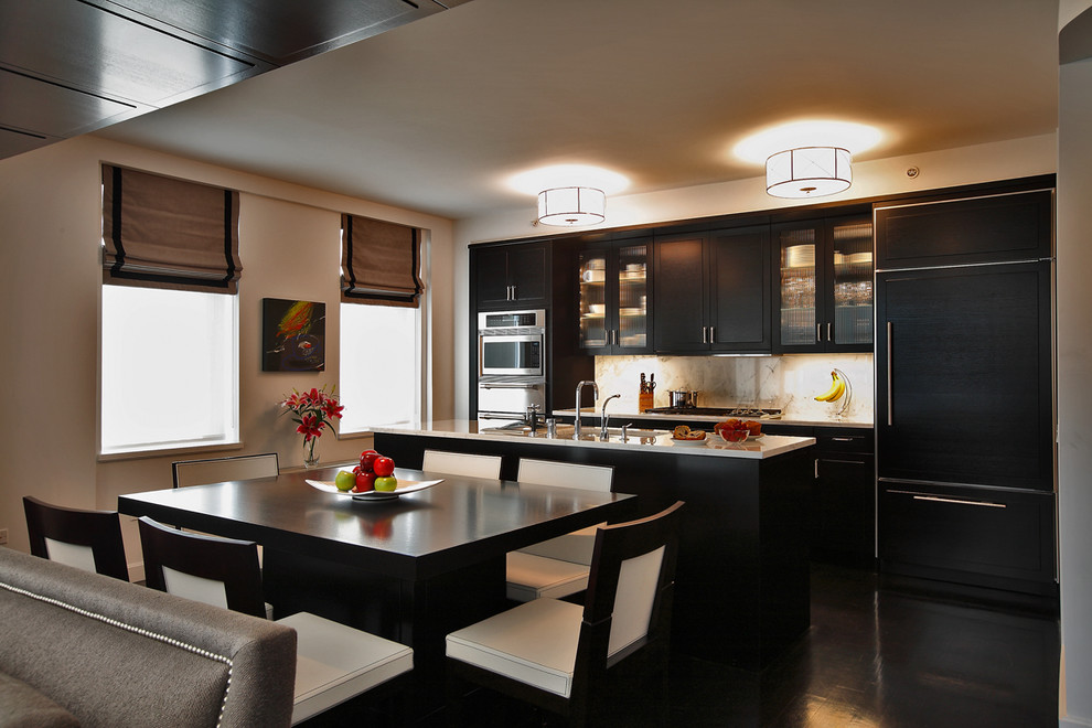 Photo of a contemporary galley kitchen in New York with glass-front cabinets, black cabinets and panelled appliances.