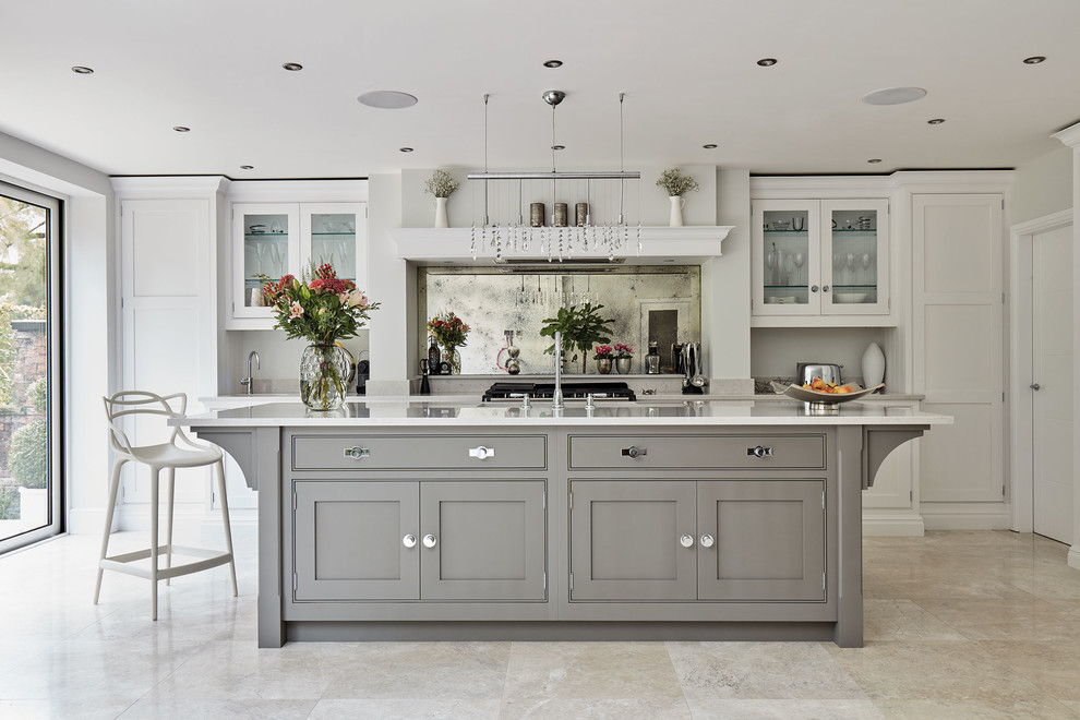 This is an example of a large transitional l-shaped eat-in kitchen in Manchester with an integrated sink, shaker cabinets, grey cabinets, quartzite benchtops, metallic splashback, mirror splashback, coloured appliances, marble floors, with island, beige floor and white benchtop.