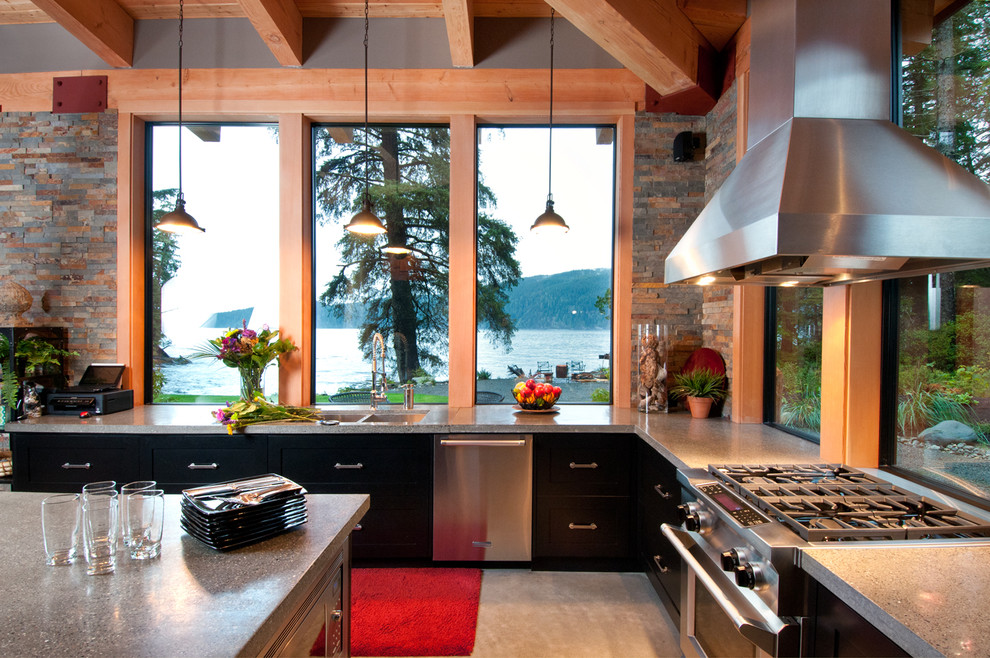 Inspiration for a contemporary kitchen in Vancouver with a double-bowl sink, flat-panel cabinets, black cabinets, stone tile splashback and stainless steel appliances.