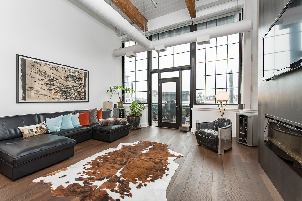 Design ideas for an industrial open concept living room in Indianapolis with white walls, dark hardwood floors, a ribbon fireplace, a wall-mounted tv and brown floor.