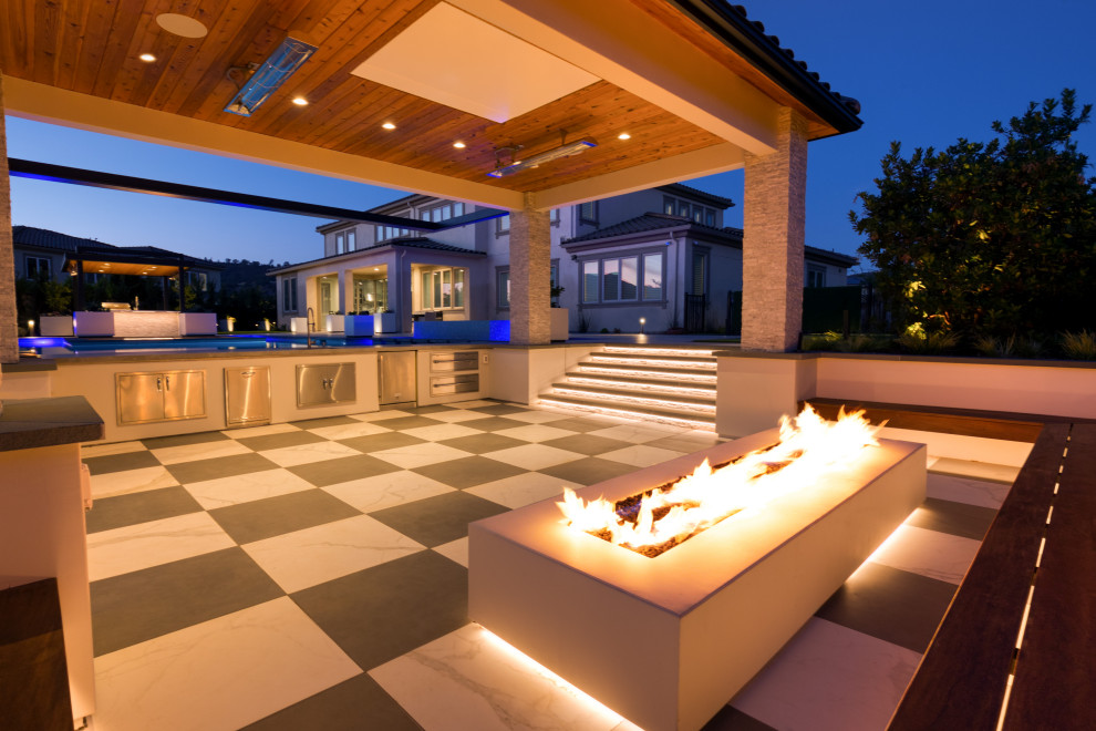 This is an example of a large transitional backyard patio in San Francisco with tile and a gazebo/cabana.