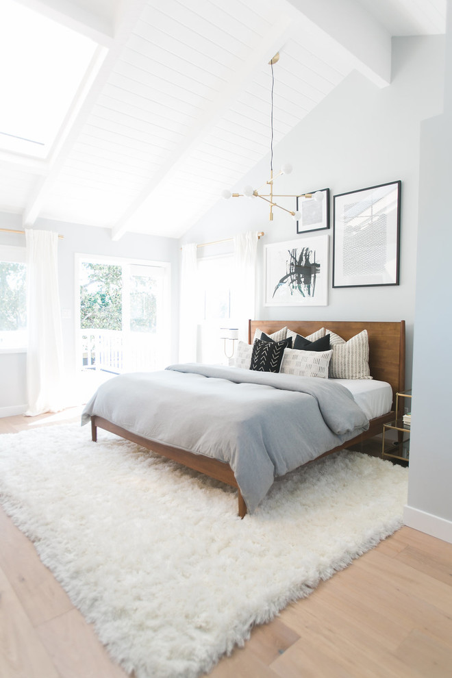 This is an example of a large midcentury master bedroom in Orange County with grey walls, light hardwood floors and no fireplace.