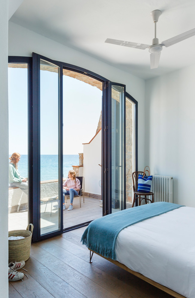 Diseño de dormitorio principal mediterráneo con paredes blancas, suelo de baldosas de cerámica y suelo multicolor