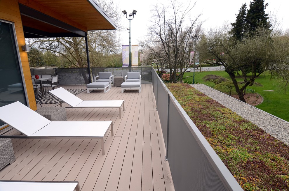 This is an example of a large scandinavian rooftop deck in Vancouver with a roof extension.