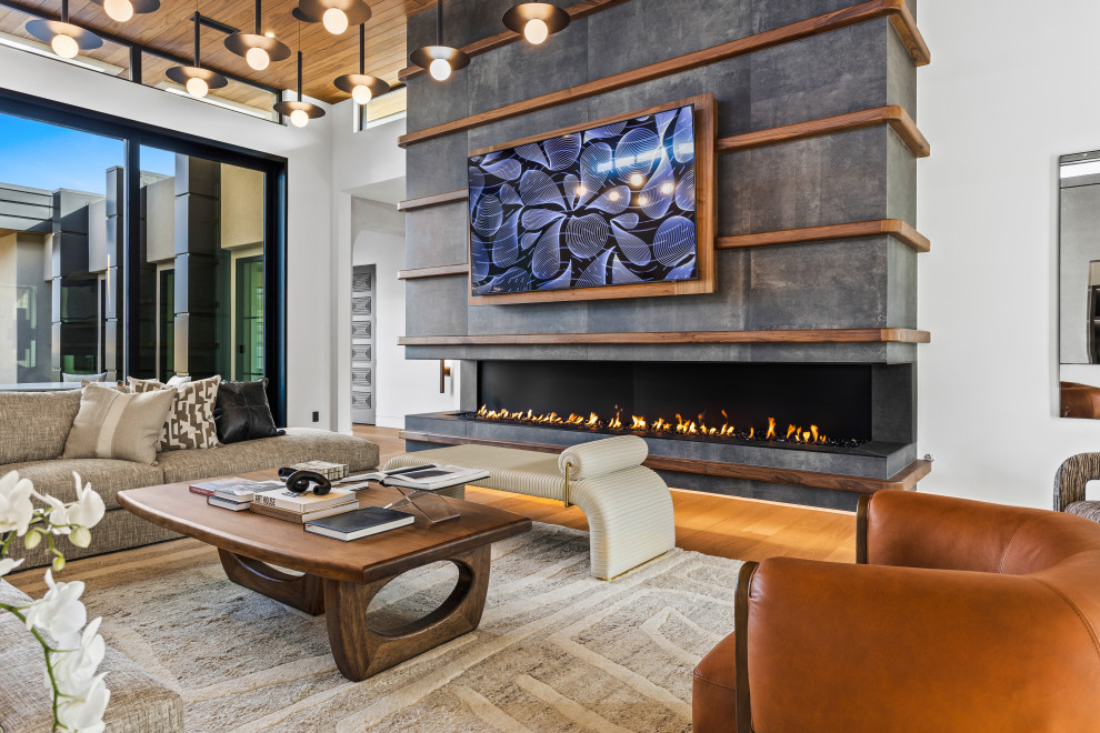 Foto de salón abierto contemporáneo con paredes blancas, suelo de madera en tonos medios, chimenea lineal, televisor colgado en la pared y suelo marrón