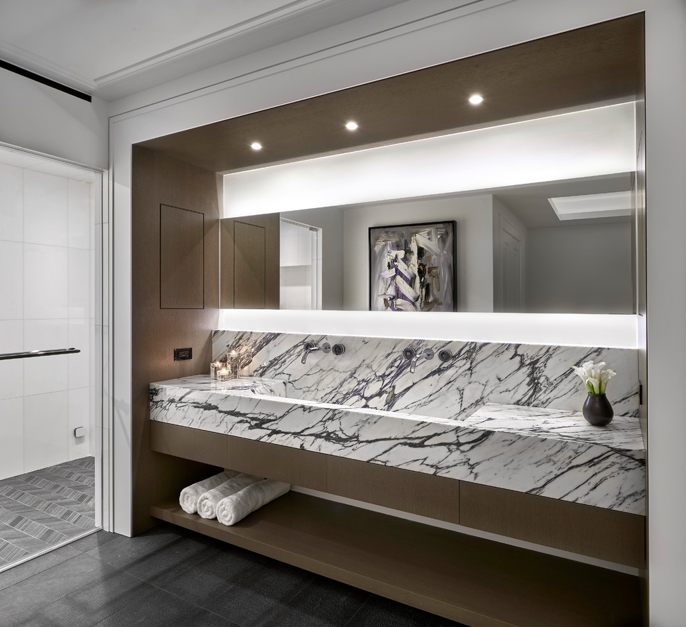 На фото: ванная комната в стиле модернизм с отдельно стоящей ванной, мраморной столешницей и тумбой под две раковины