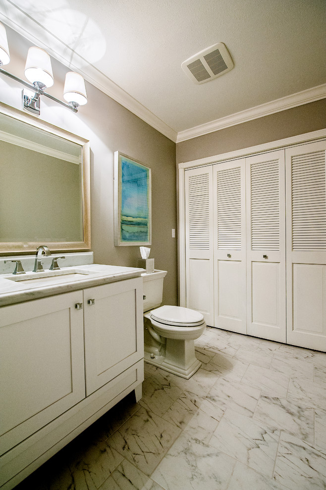 Inspiration for a large beach style powder room in Boston with shaker cabinets, white cabinets, a two-piece toilet, grey walls, marble floors, an undermount sink, quartzite benchtops and white floor.