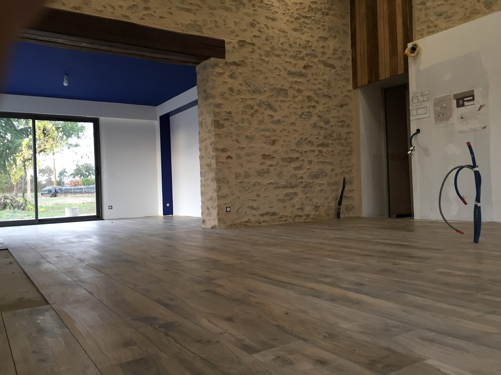 Photo of a large modern open concept family room in Nantes with blue walls, ceramic floors, a corner tv and beige floor.