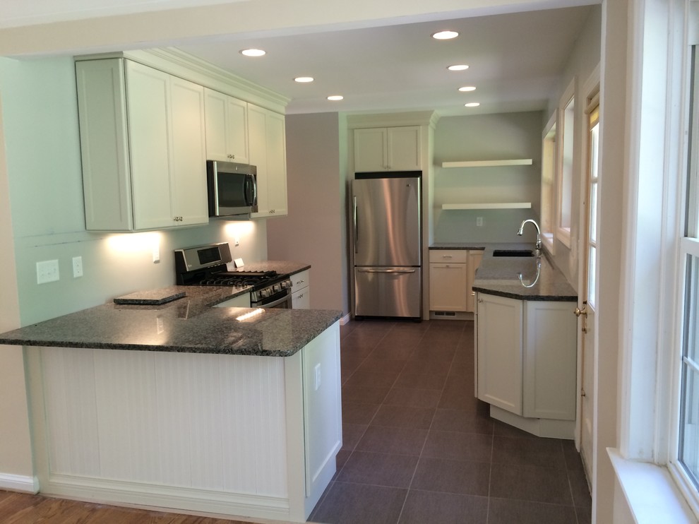 Kitchen - mid-sized transitional galley kitchen idea in St Louis with a double-bowl sink, shaker cabinets, white cabinets, granite countertops, stainless steel appliances and a peninsula