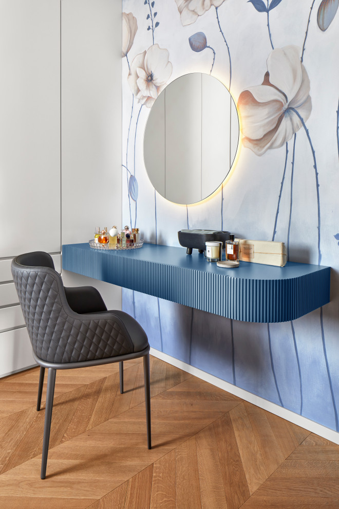 Immagine di uno studio design con pareti blu, carta da parati, parquet chiaro e scrivania autoportante