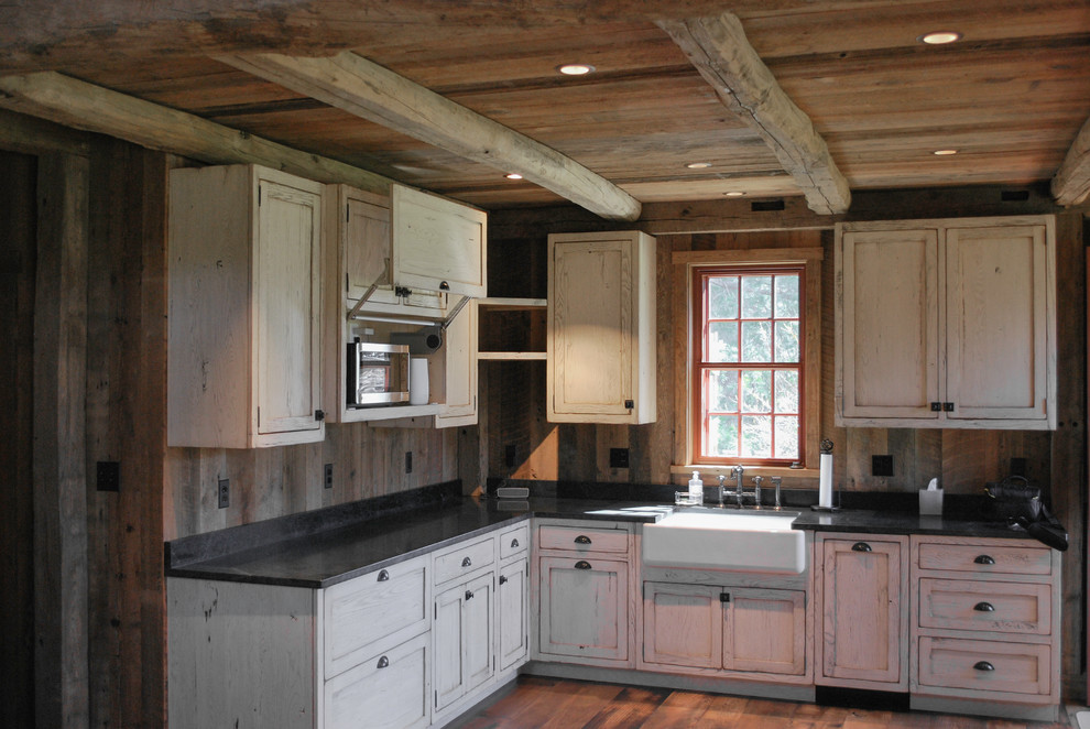 Inspiration for a mid-sized country l-shaped open plan kitchen in DC Metro with a farmhouse sink, shaker cabinets, distressed cabinets, soapstone benchtops, timber splashback, stainless steel appliances and medium hardwood floors.
