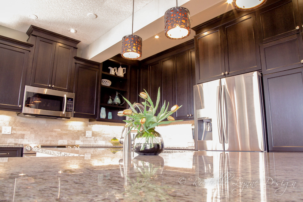 Eat-in kitchen - mid-sized transitional l-shaped light wood floor eat-in kitchen idea in Calgary with an undermount sink, recessed-panel cabinets, dark wood cabinets, granite countertops, beige backsplash, stone tile backsplash, stainless steel appliances and an island