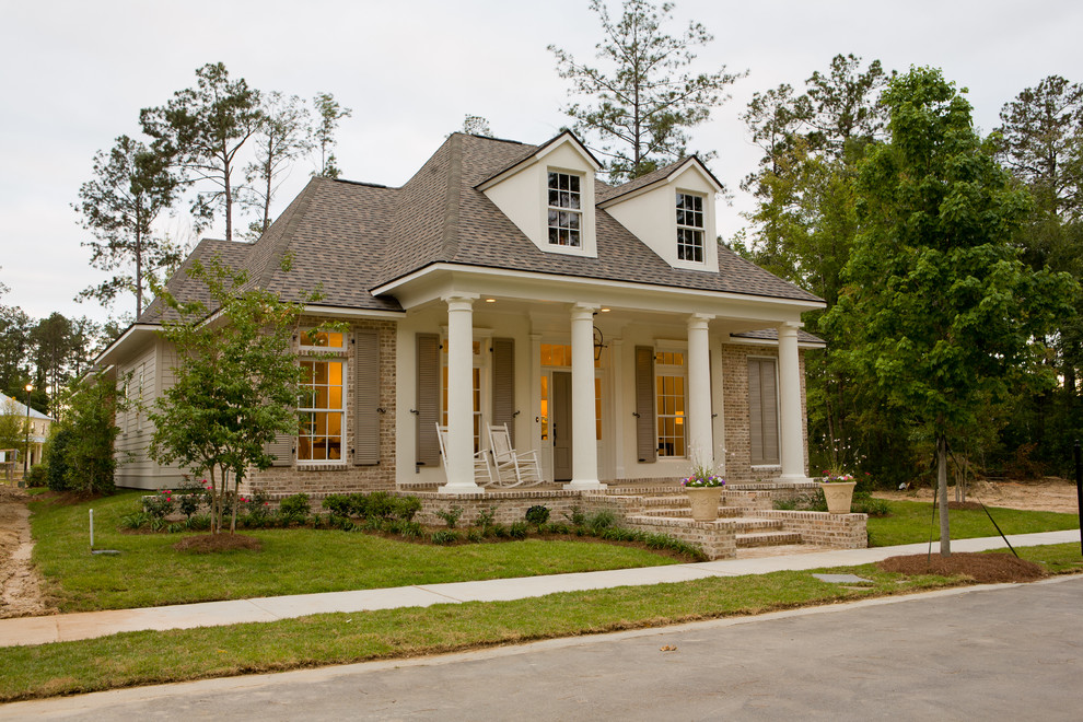 Inspiration for a large traditional two-storey beige exterior in New Orleans with mixed siding and a hip roof.