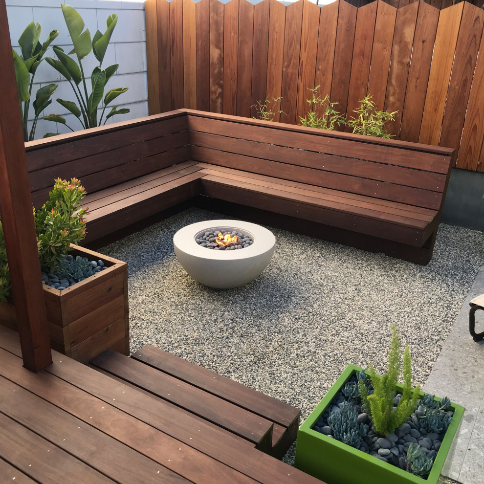 Photo of a small contemporary drought-tolerant and partial sun backyard wood fence landscaping in San Francisco with decking.