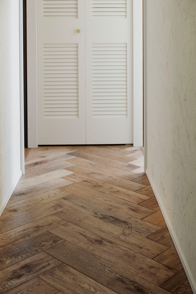 Mid-sized beach style medium tone wood floor, brown floor, wallpaper ceiling and shiplap wall hallway photo in Tokyo with white walls