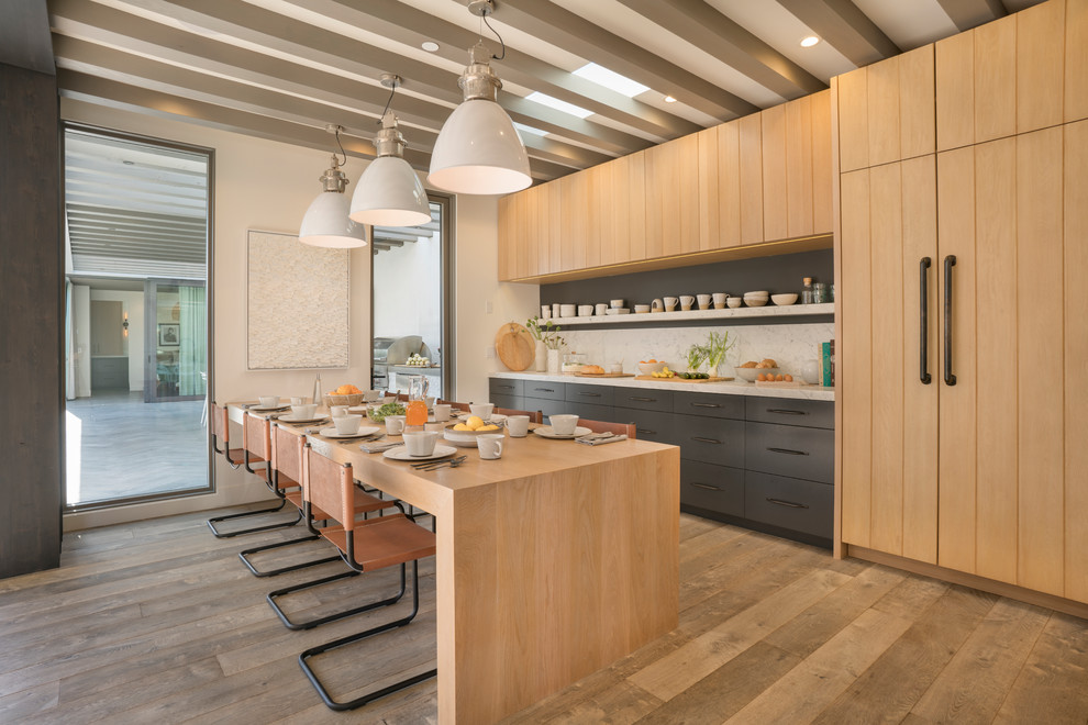 Design ideas for a beach style single-wall eat-in kitchen in Orange County with flat-panel cabinets, medium wood cabinets, white splashback, panelled appliances, medium hardwood floors, a peninsula and brown floor.