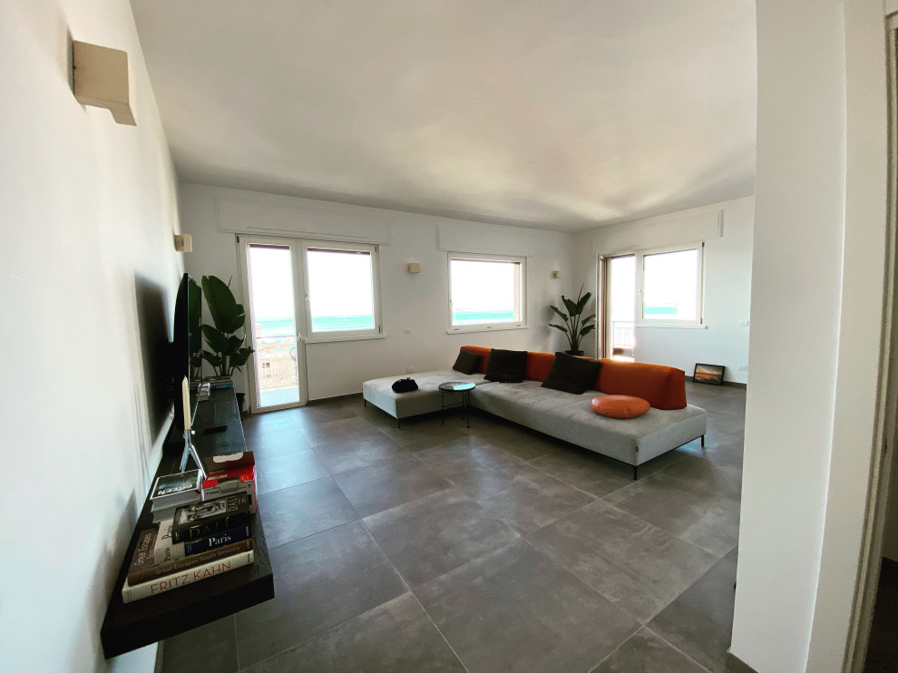 Réalisation d'une salle de séjour minimaliste de taille moyenne et fermée avec un mur blanc, un sol en carrelage de porcelaine, un téléviseur fixé au mur, un sol gris et un plafond décaissé.