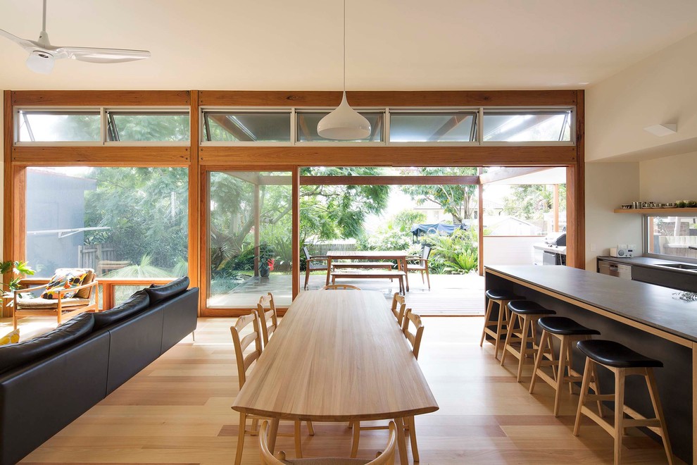 This is an example of a mid-sized contemporary open plan dining in Sydney with white walls, medium hardwood floors, no fireplace and brown floor.