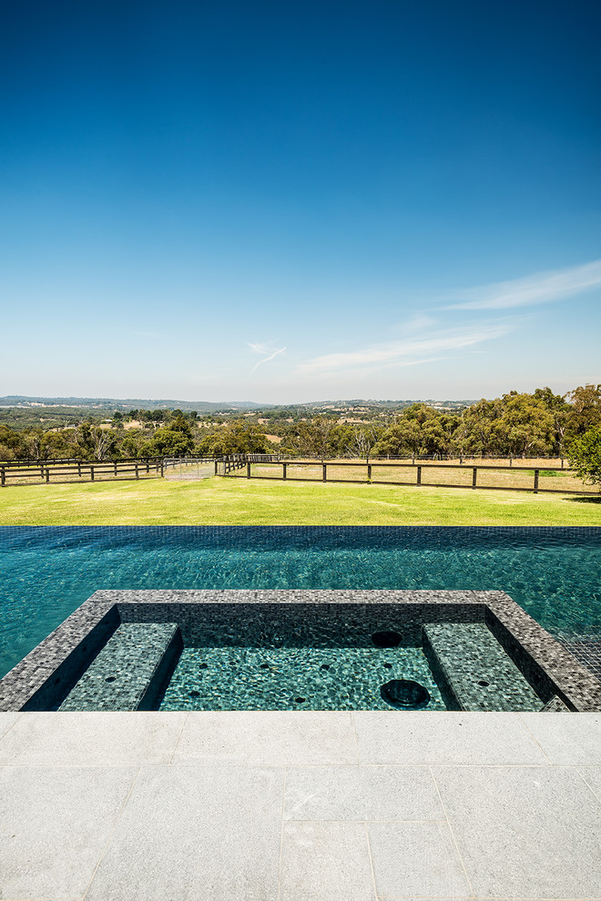 Design ideas for a large modern backyard rectangular infinity pool in Melbourne.