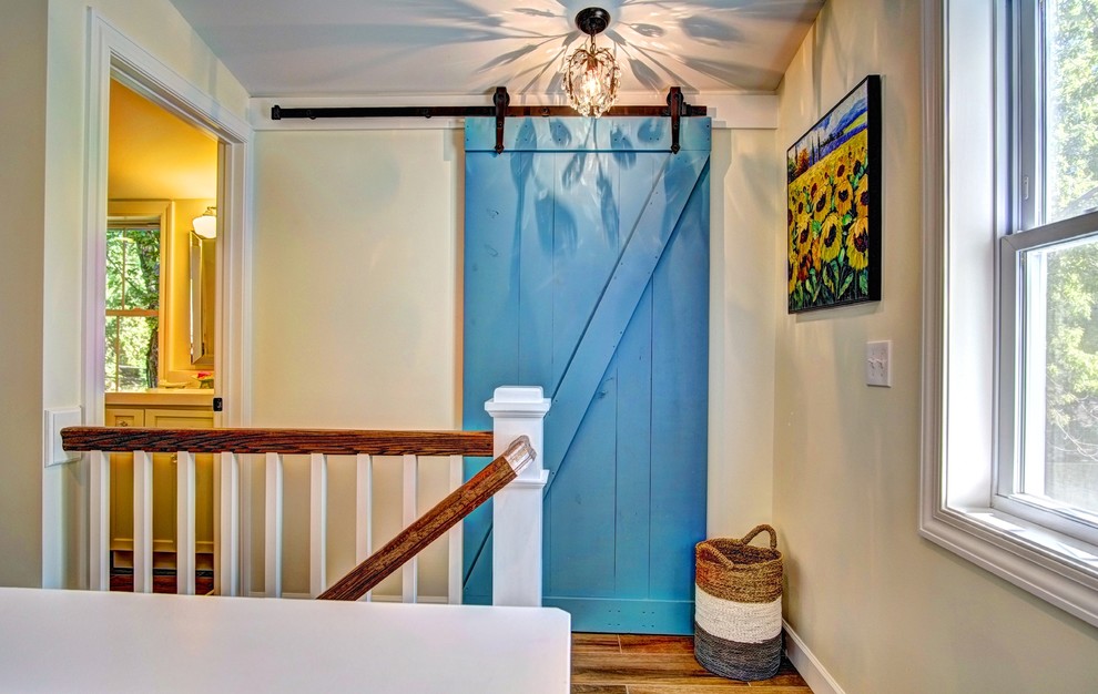 This is an example of a mid-sized country hallway in Minneapolis with white walls and medium hardwood floors.