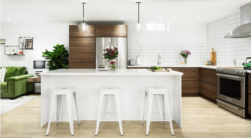Mid-sized contemporary l-shaped separate kitchen in Toronto with a double-bowl sink, flat-panel cabinets, medium wood cabinets, quartzite benchtops, white splashback, ceramic splashback, stainless steel appliances, light hardwood floors, with island, beige floor and white benchtop.