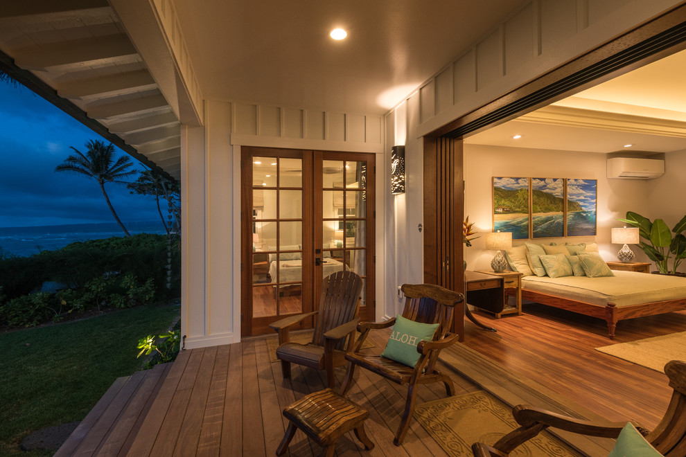 Design ideas for a beach style bedroom in Hawaii with grey walls, medium hardwood floors and brown floor.