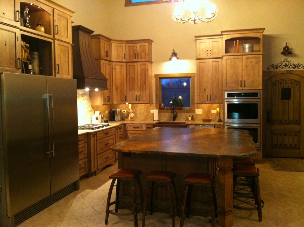 Inspiration for a large rustic l-shaped porcelain tile open concept kitchen remodel in Chicago with a farmhouse sink, recessed-panel cabinets, medium tone wood cabinets, granite countertops, beige backsplash, stone slab backsplash, stainless steel appliances and an island
