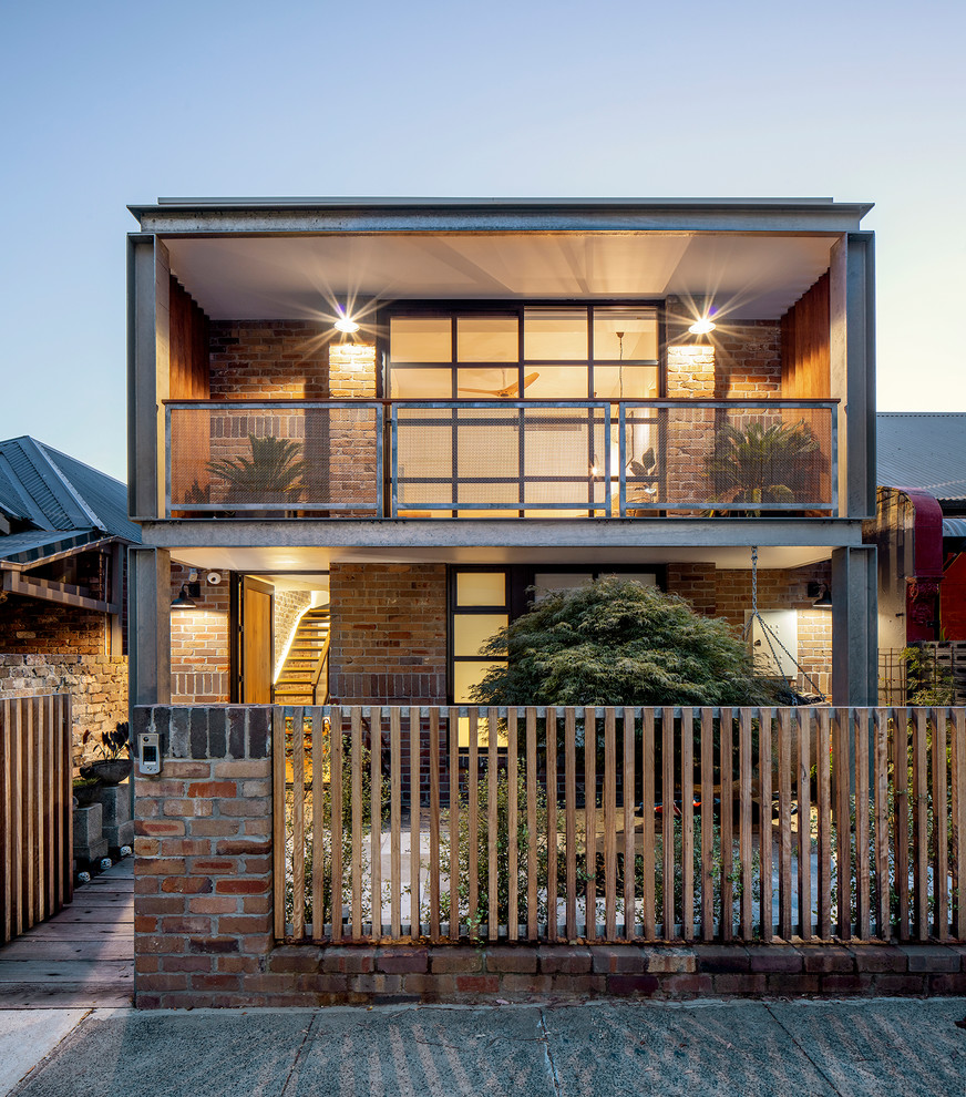 Inspiration for a contemporary two-storey brick red house exterior in Sydney with a flat roof.