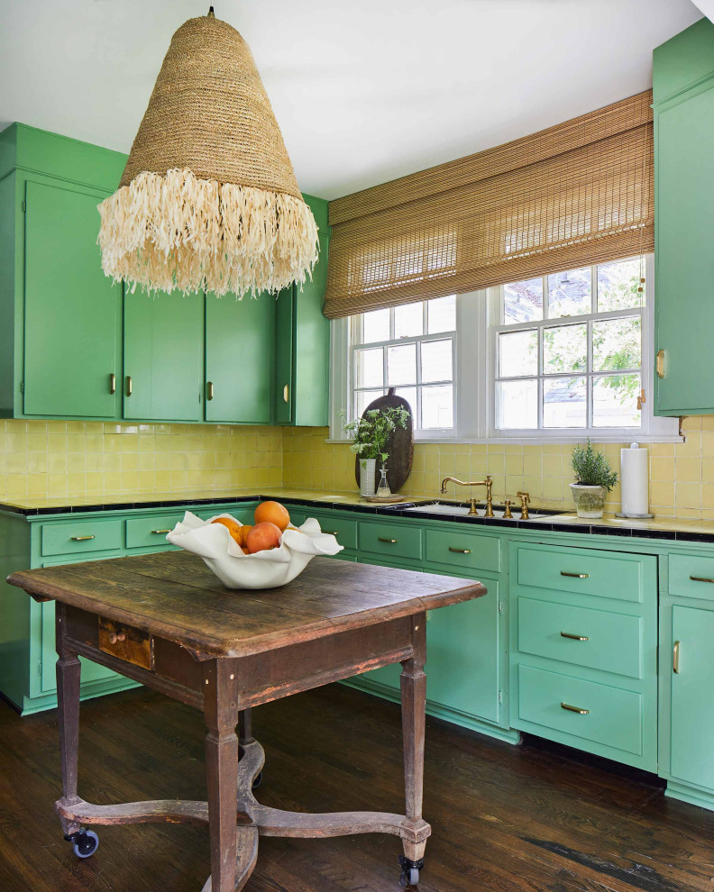 Inspiration for a tropical kitchen in Other with an undermount sink, flat-panel cabinets, green cabinets, tile benchtops, yellow splashback, dark hardwood floors, with island, brown floor and yellow benchtop.