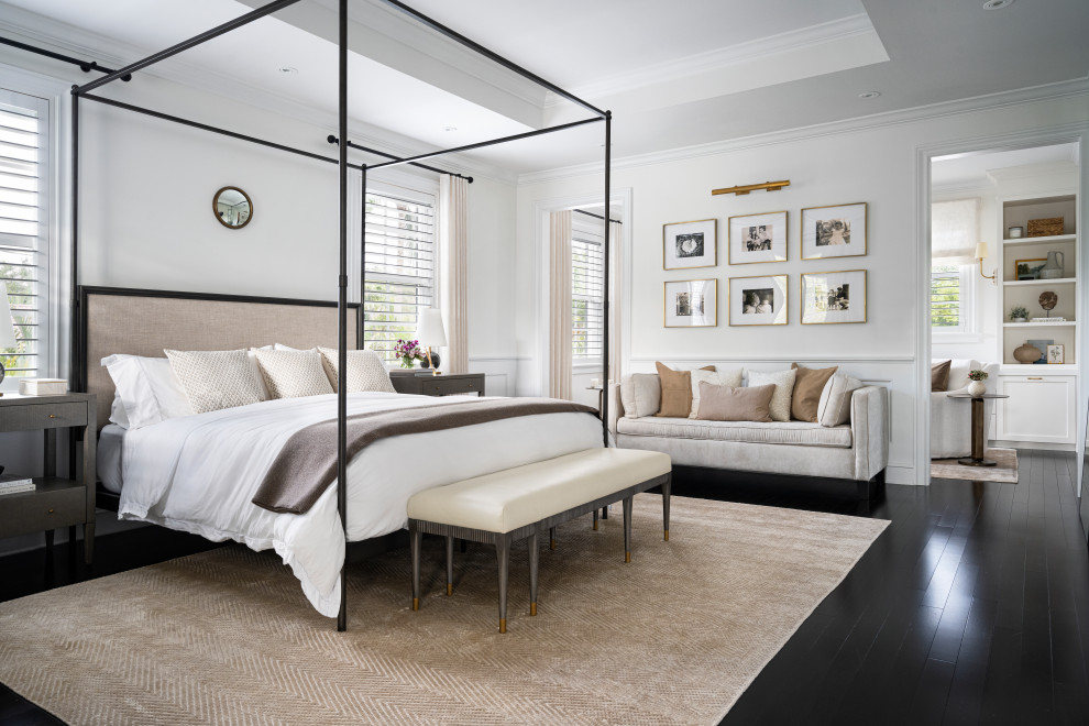 Photo of a transitional master bedroom in Miami with white walls, dark hardwood floors, black floor and panelled walls.