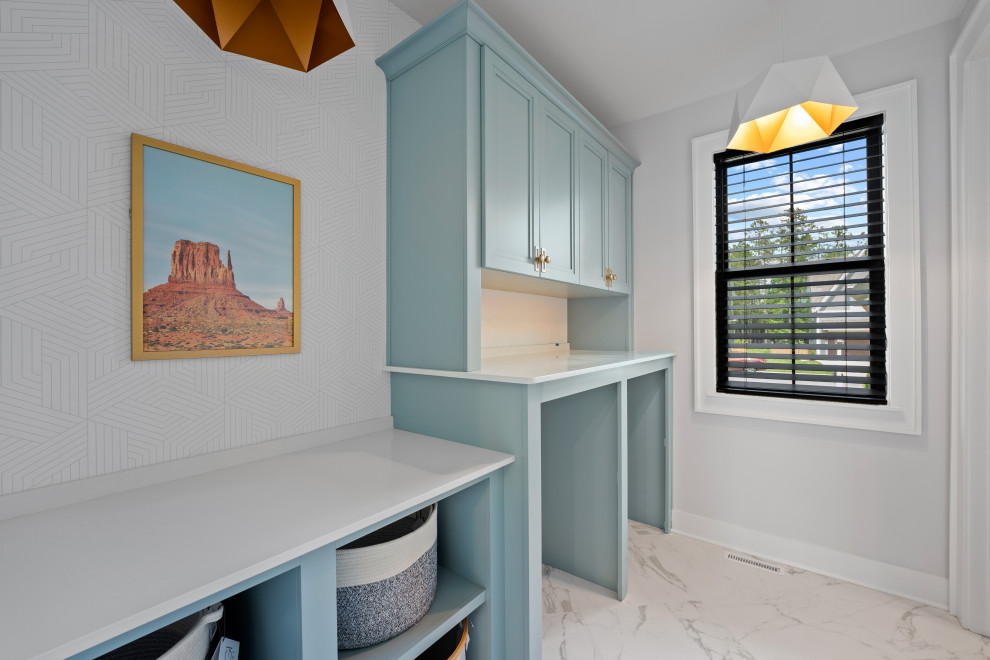 Design ideas for a mid-sized contemporary single-wall dedicated laundry room in Richmond with recessed-panel cabinets, turquoise cabinets, quartz benchtops, white walls, marble floors, an integrated washer and dryer, white floor, white benchtop and wallpaper.