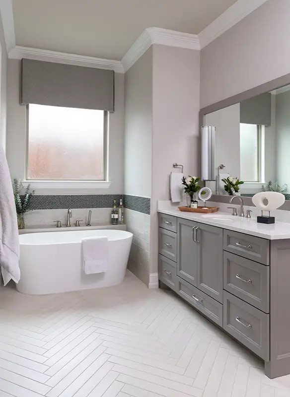 На фото: главная ванная комната среднего размера в стиле неоклассика (современная классика) с серыми фасадами, отдельно стоящей ванной, разноцветной плиткой, серыми стенами, врезной раковиной, белым полом, белой столешницей и тумбой под одну раковину
