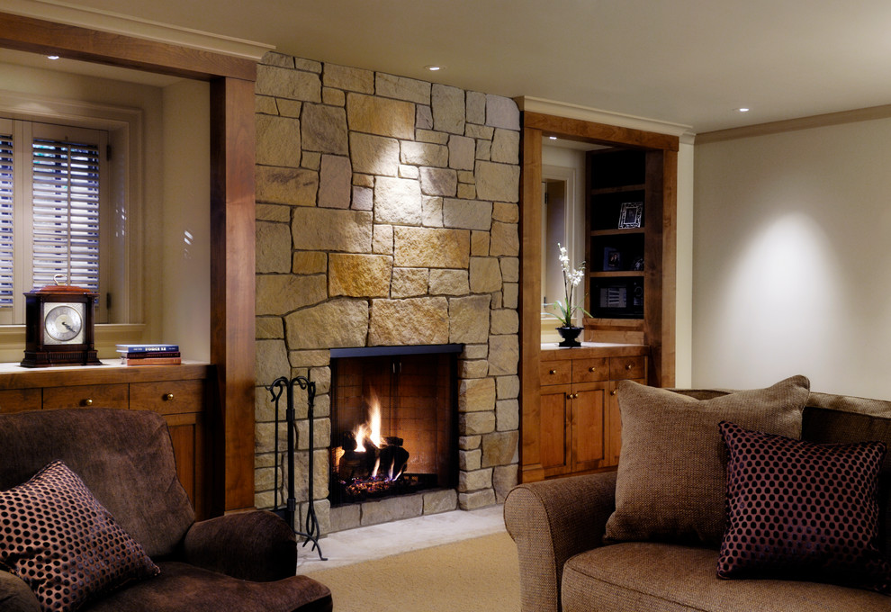 Photo of a traditional family room in Seattle with beige walls, a standard fireplace, a stone fireplace surround, a built-in media wall and white floor.