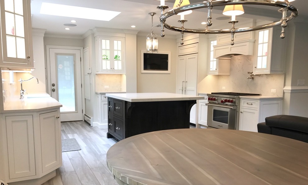 Inspiration for a mid-sized transitional u-shaped light wood floor and brown floor open concept kitchen remodel with a farmhouse sink, recessed-panel cabinets, white cabinets, marble countertops, white backsplash, marble backsplash, stainless steel appliances and an island