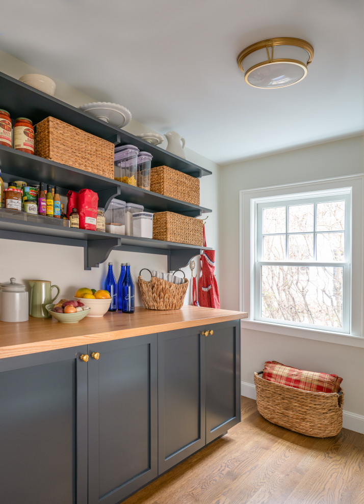 Inspiration for a mid-sized timeless medium tone wood floor kitchen pantry remodel in Boston with raised-panel cabinets, wood countertops and brown countertops