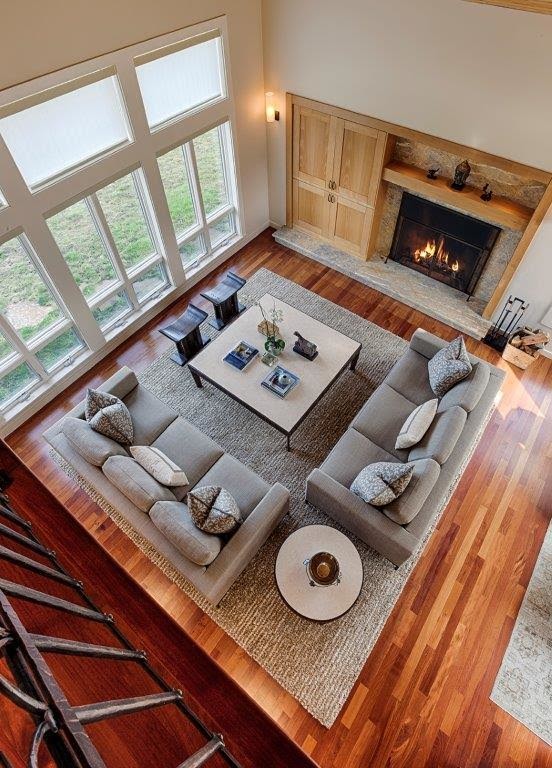 Photo of a mid-sized transitional open concept living room in San Francisco with beige walls, medium hardwood floors, a standard fireplace and a stone fireplace surround.