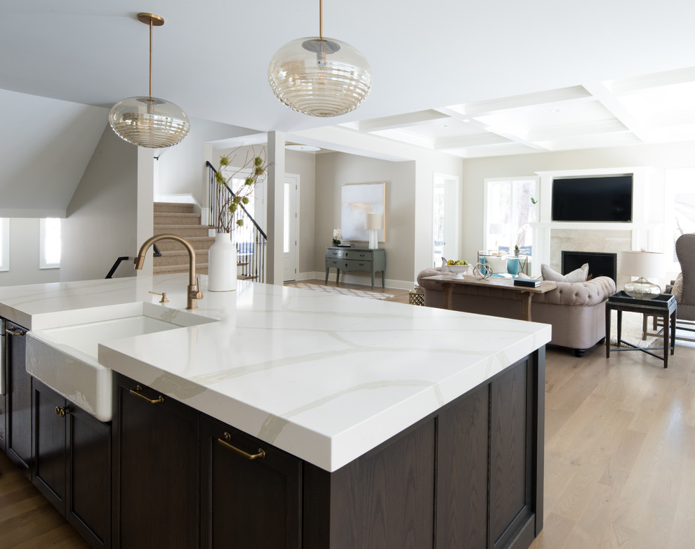 Inspiration for a mid-sized transitional galley light wood floor and beige floor open concept kitchen remodel in Minneapolis with a farmhouse sink, gray cabinets, quartz countertops, stainless steel appliances, an island, recessed-panel cabinets, gray backsplash and ceramic backsplash