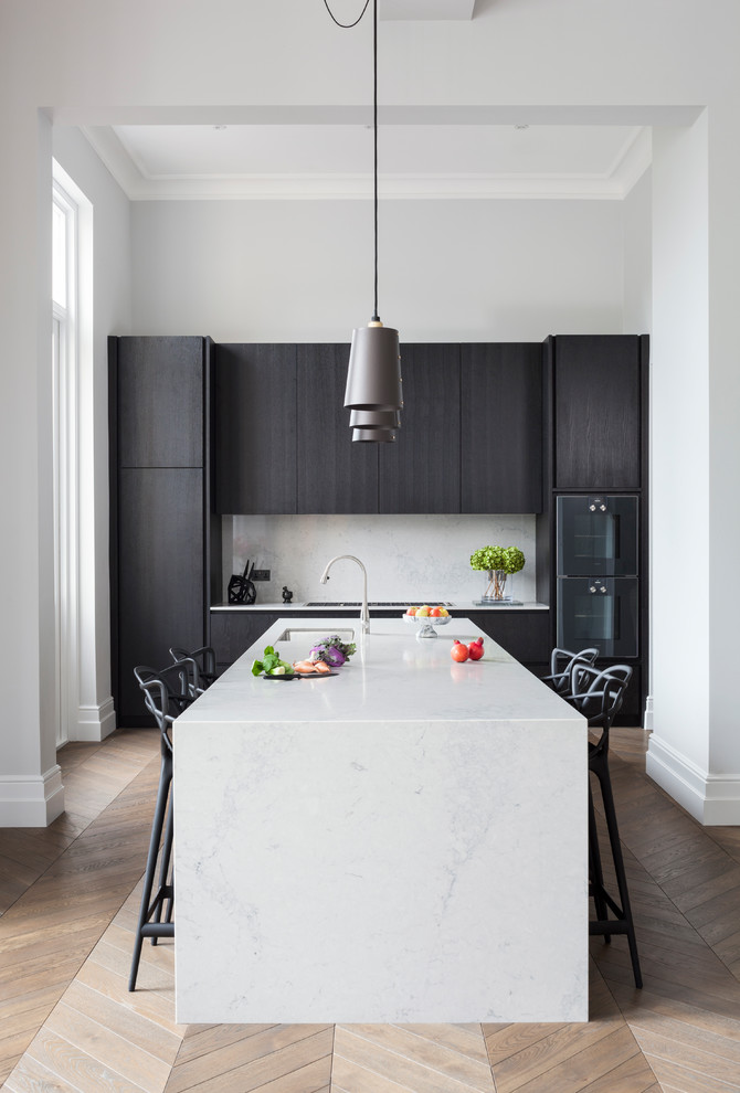 Inspiration for a mid-sized contemporary single-wall eat-in kitchen in London with flat-panel cabinets, dark wood cabinets, medium hardwood floors, brown floor, black appliances, an integrated sink, solid surface benchtops, stone slab splashback and a peninsula.