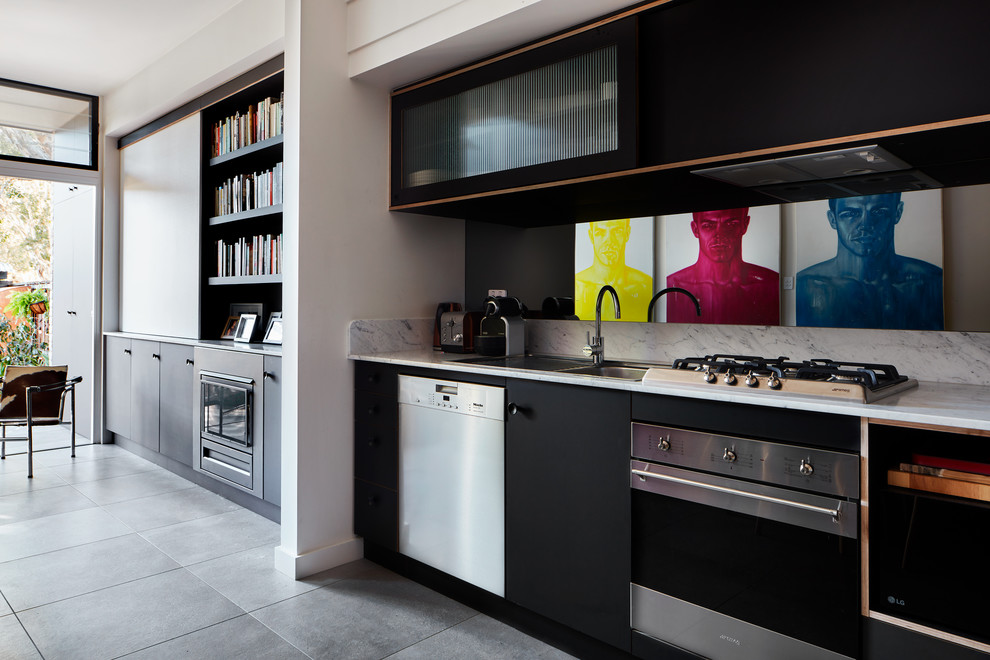 Inspiration for a contemporary kitchen in Sydney with black cabinets, granite benchtops, grey floor, a double-bowl sink, flat-panel cabinets, white splashback, stainless steel appliances and white benchtop.