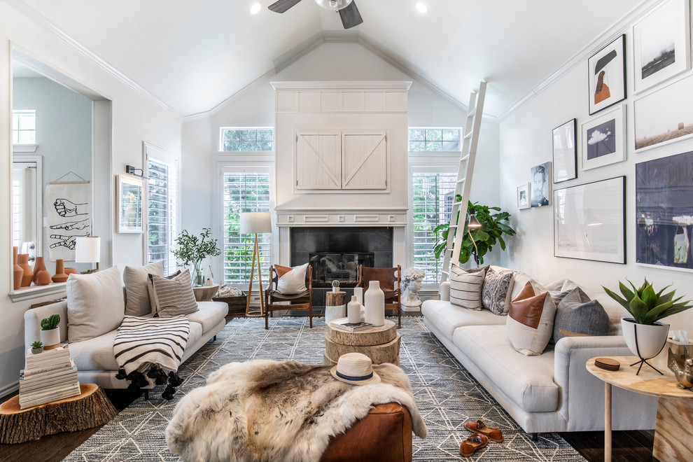 Photo of a large beach style open concept living room in Dallas with white walls, dark hardwood floors, a concealed tv, a standard fireplace, a wood fireplace surround and brown floor.