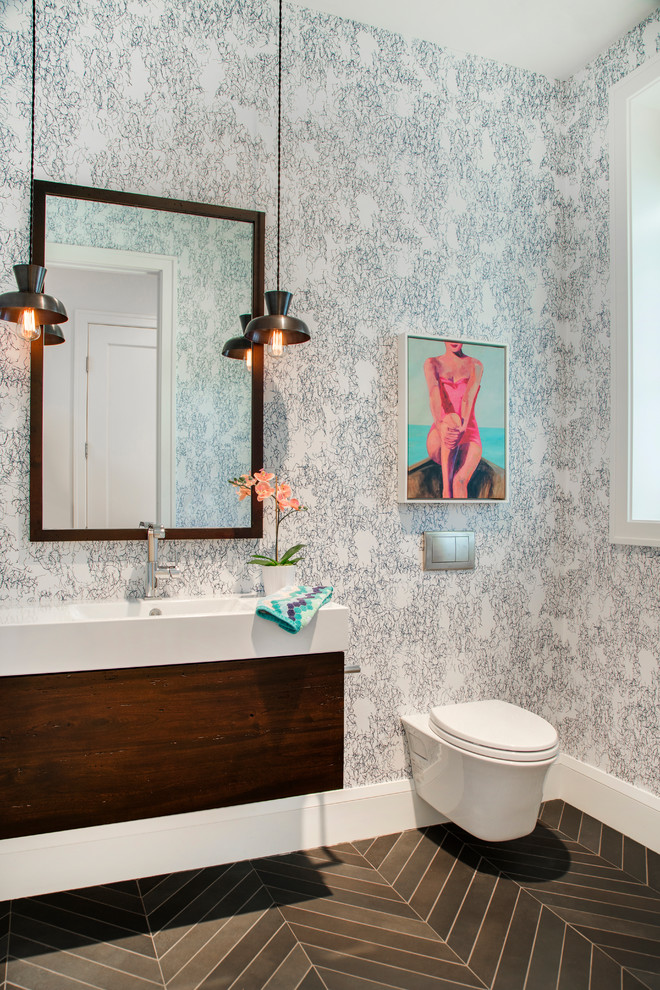Contemporary powder room in Minneapolis with flat-panel cabinets, dark wood cabinets, a wall-mount toilet, multi-coloured walls, an integrated sink and grey floor.