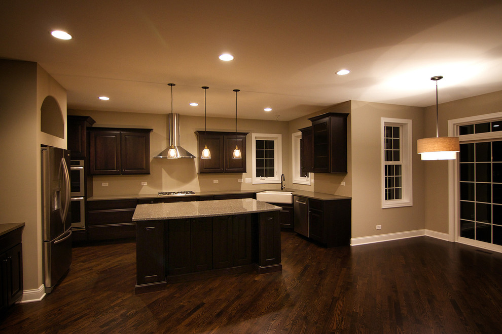 Enclosed kitchen - mid-sized transitional single-wall dark wood floor enclosed kitchen idea in Chicago with recessed-panel cabinets, white cabinets, solid surface countertops, white backsplash, porcelain backsplash, stainless steel appliances, an island and a farmhouse sink