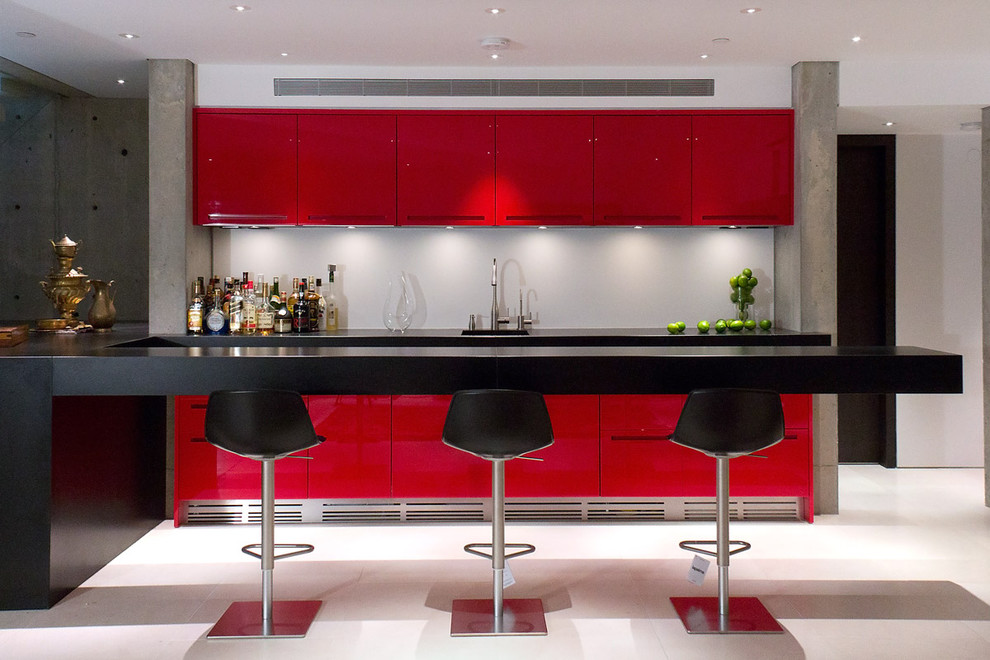 This is an example of a mid-sized contemporary u-shaped seated home bar in Vancouver with flat-panel cabinets, red cabinets and white floor.