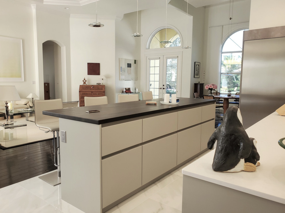 Large contemporary l-shaped eat-in kitchen in Atlanta with an integrated sink, flat-panel cabinets, grey cabinets, quartz benchtops, white splashback, engineered quartz splashback, stainless steel appliances, ceramic floors, multiple islands, white floor, white benchtop and recessed.